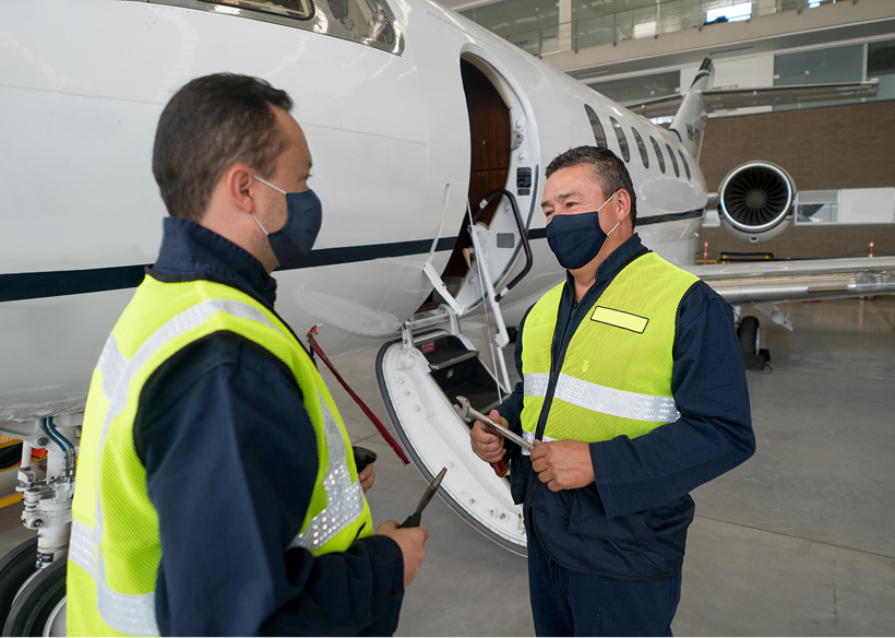 Maintenance crew in hangar with airplane