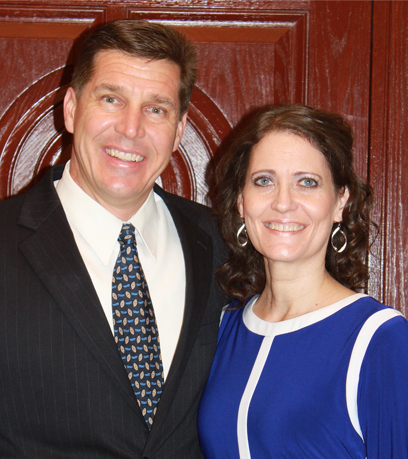 Smiling couple posing in formal attire.