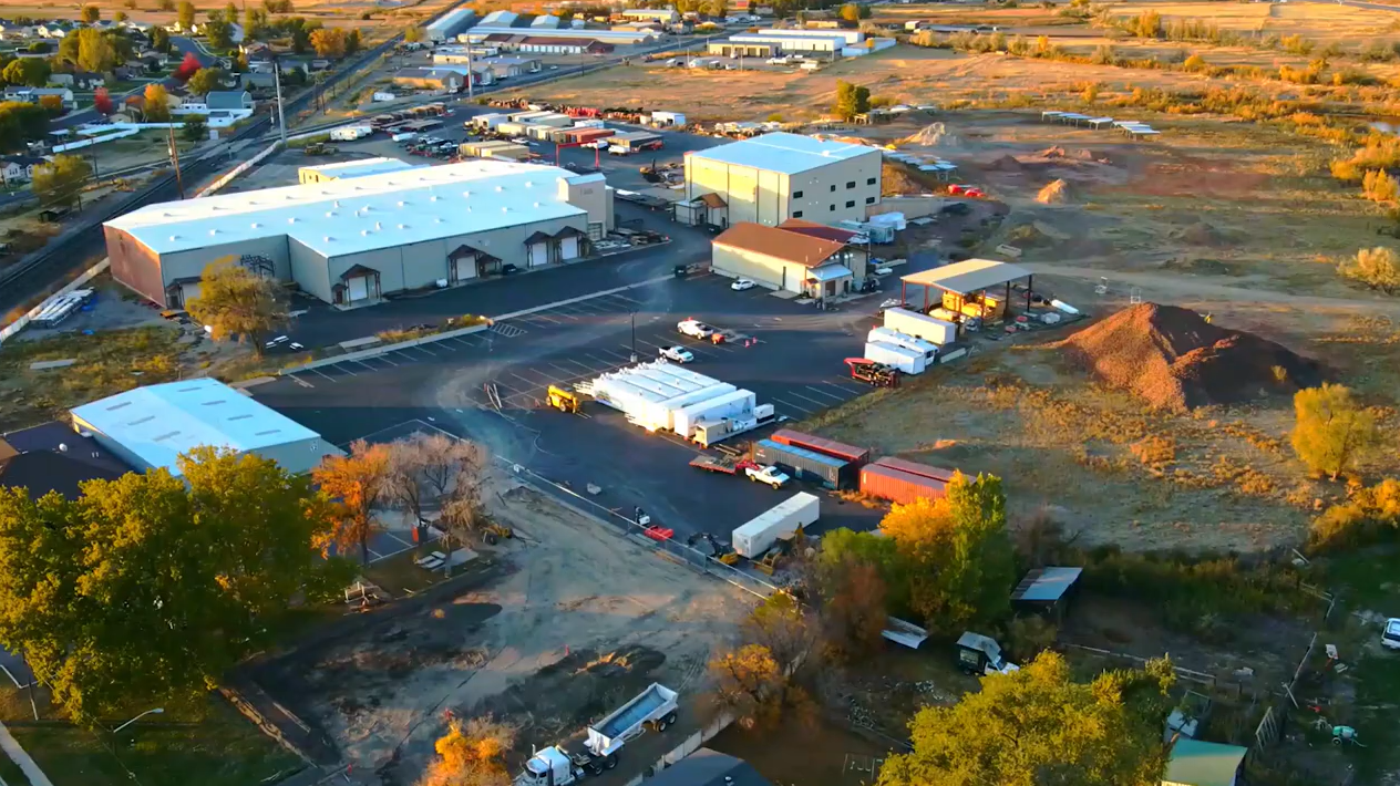 Industrial area with buildings and trucks, aerial view.