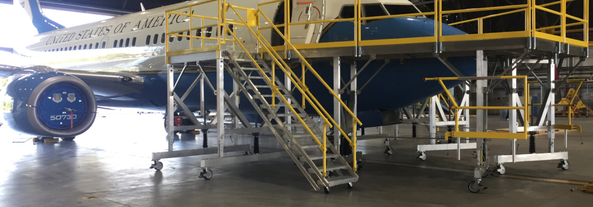 Aircraft undergoing maintenance inside a hangar with scaffolding around its nose.