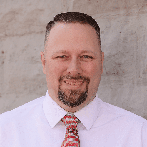 Smiling man in white shirt and tie.