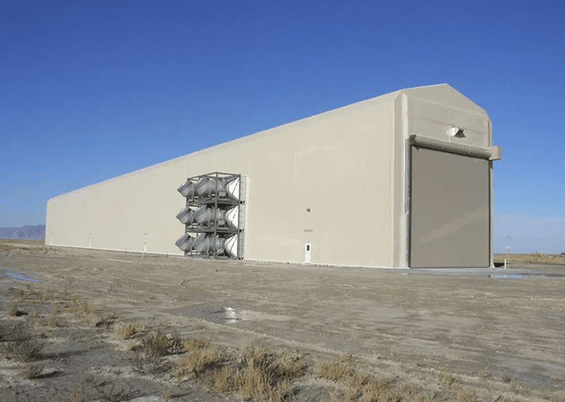 Large beige building with ventilation systems outside.