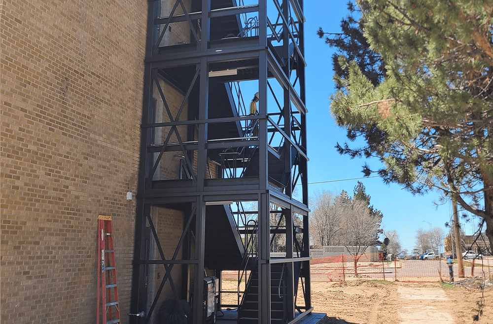 Outdoor metal staircase beside brick building.