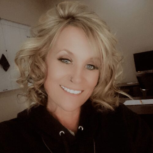 Smiling woman with curly blonde hair.