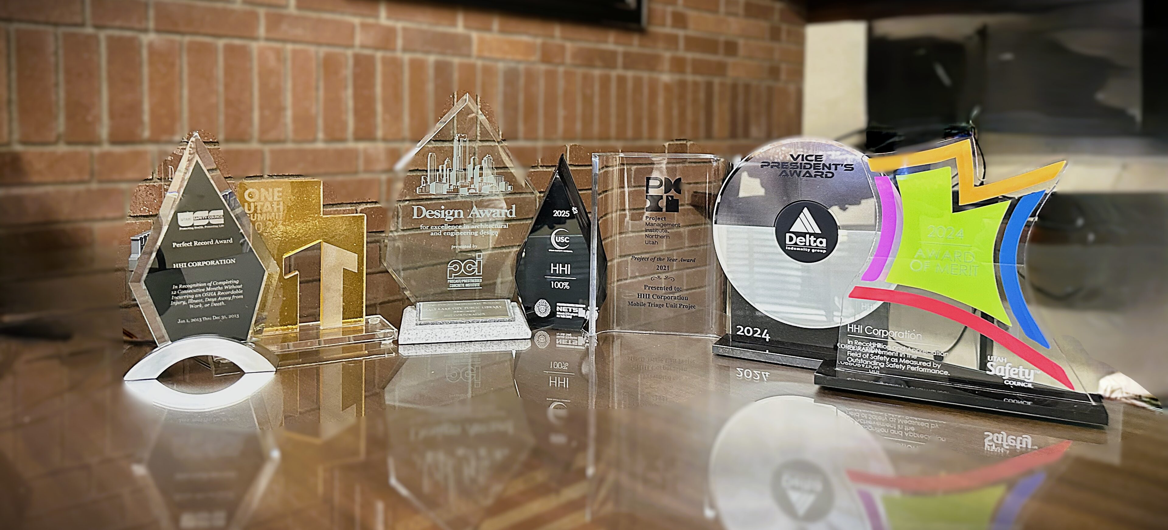 Various awards displayed on a reflective surface.