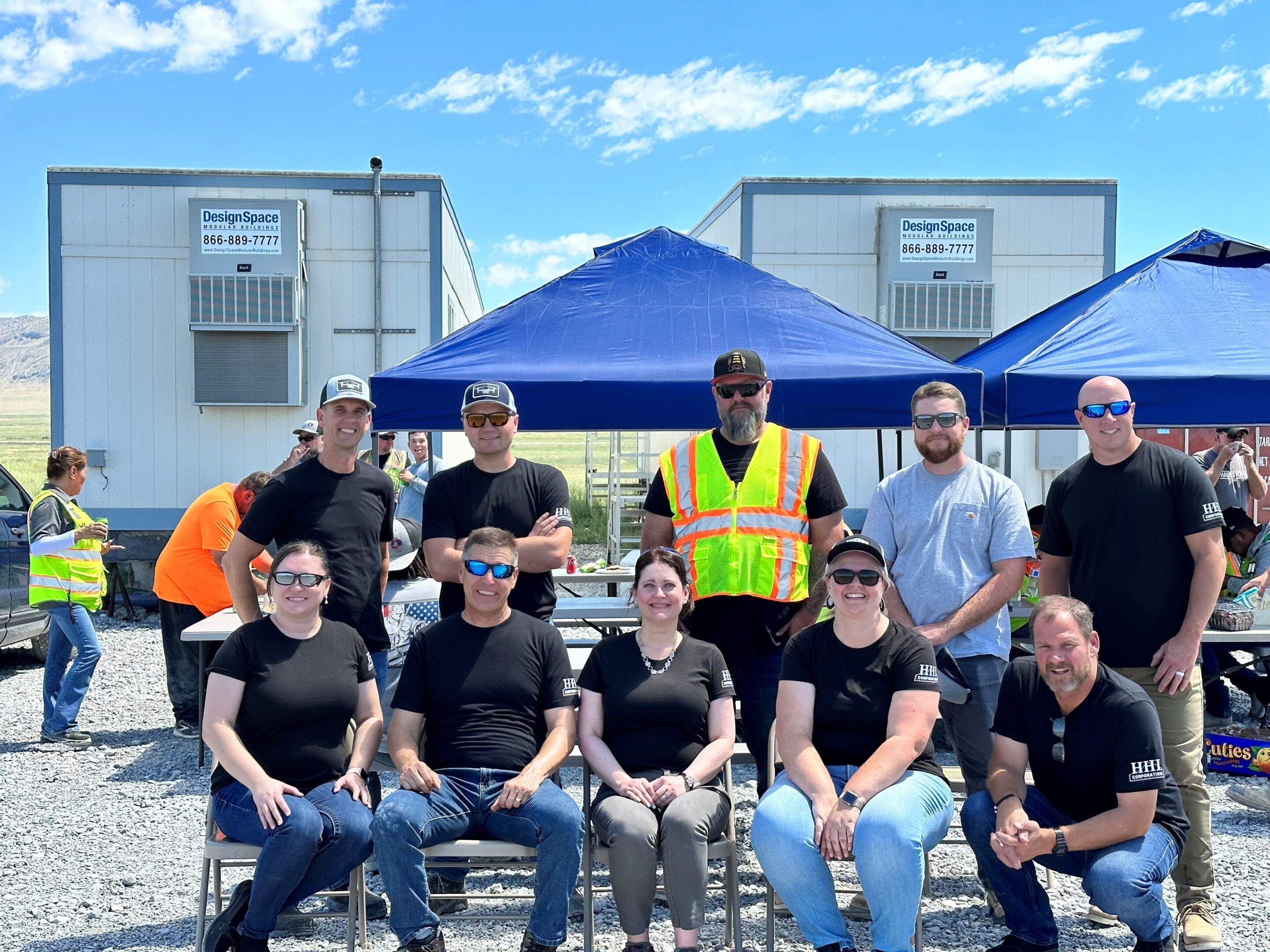 Group of people posing outdoors, construction site.