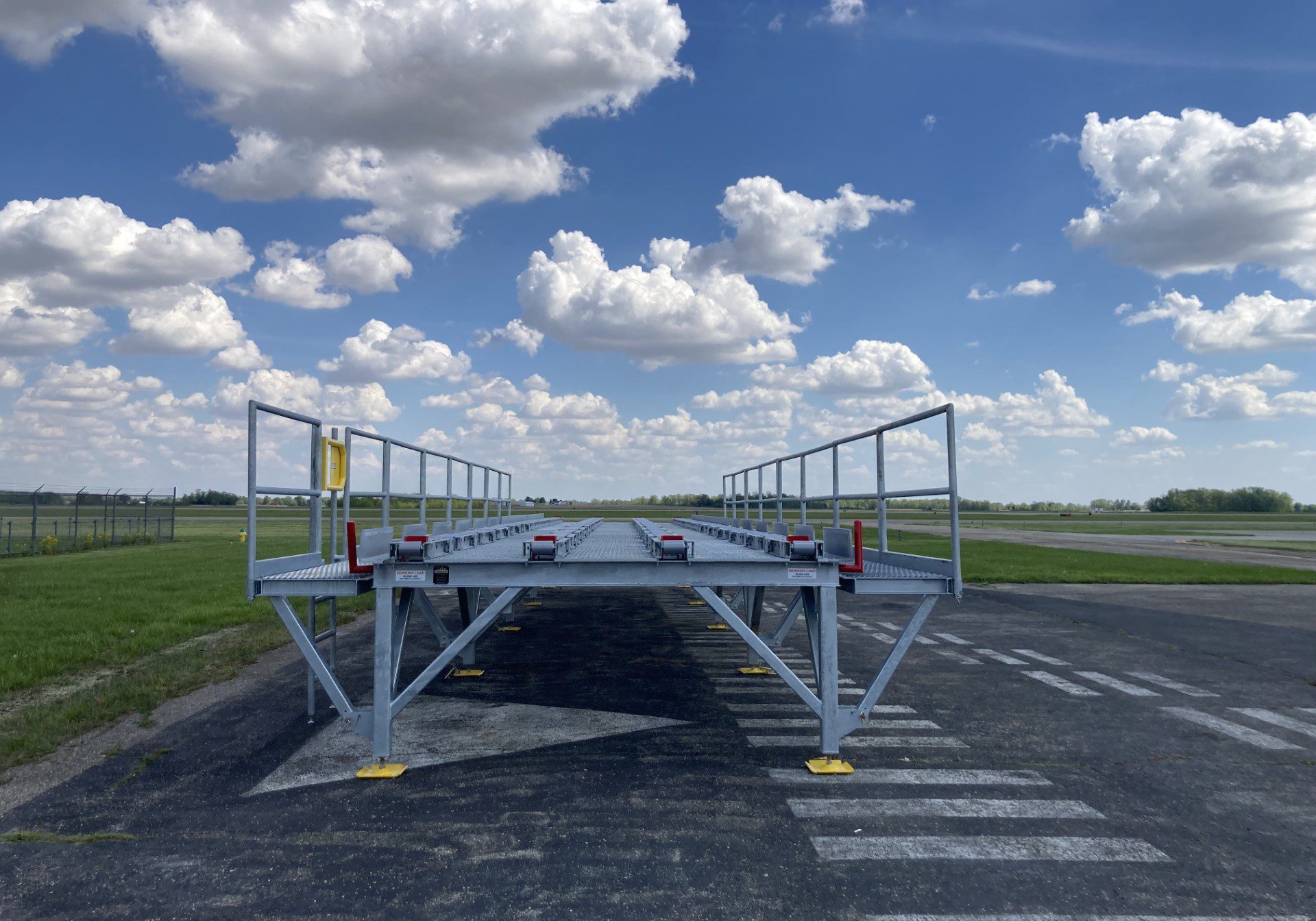Airport ramp under a cloudy blue sky.